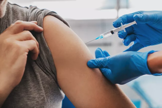Person receiving needle injection in arm Person receiving needle injection in arm