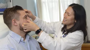 Clarissa Yang, MD, Chief of Dermatology at Tufts Medical Center, examines patient for skin cancer during a clinic appointment.