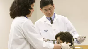 Neurosurgeon Julian Wu, MD and Kerry Mahn, RN fitting headpiece used in Gamma Knife procedure on patient at Tufts Medical Center.