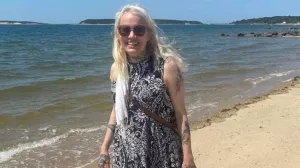 Breast cancer survivor, Susannah, poses on the beach.