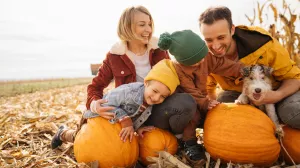 Family laughing in a pumpkin patch