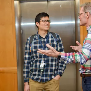 Jon Michael Saenz, MD talking to colleague at a Tufts Medical Center event.