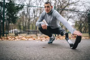 Motivated amputee athlete stretching before running.