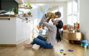 Mother playing with baby in home.