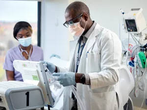 Palcide Colas, RRT (Respiratory Therapist) and Ornelia Moise, RN treating sleep medicine patient with a CPAP.