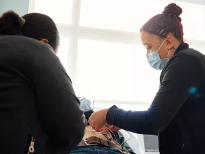 Katrina Landaverde, CCMA and Bernanie St. Juste, MA (both medical assistants at Tufts Medical Center) testing a heart patient at a cardiovascular appointment.