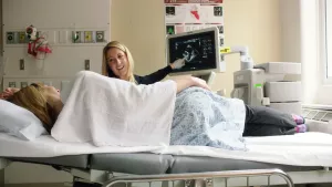 A Tufts Medical Center echocardiogram technologist explains the screen to Hypertrophic Cardiomyopathy Center (HCM) patient.