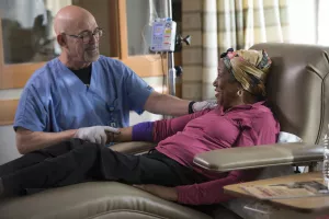 Clinical Nurse Leader, Mark Diethelm, checking infusion line of patient in Tufts Medical Center 's Neely Stem Cell Center.