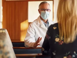 Greg Schumaker, MD (Medical Director at Lowell General Hospital's ICU, Section Chief of Critical Care, Adult Sleep Medicine) talking to a family member in the waiting room of the Intensive Care Unit (ICU).