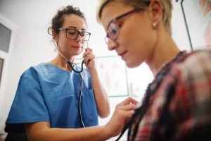 Doctor listening to a patient's lungs during an appointment and using a stethoscope.