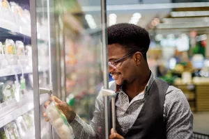 Patient with food allergies reading the ingredients on a food product in the grocery store and happy to find out it does not list their intolerance.