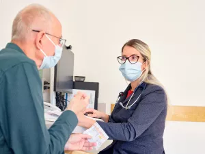 Natalie Bonvie-Hill, Nurse Practitioner at Tufts Medical Center, talks to a cardio-oncology patient during a clinic appointment at Tufts Medical Center.