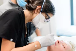 Farah Moustafa, MD, FAAD providing acne scar treatment to patient in the Cosmetic and Laser Center within the Dermatology Department at Tufts Medical Center.