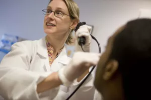 Otolaryngologist Miriam O'Leary, MD, using scope on patient at an appointment in the ENT clinic at Tufts Medical Center.