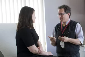 Andreas Klein, MD of Tufts Medical Center's Cancer Center talking to patient in a clinic appointment.