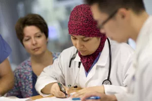 Resident filling out paperwork in the SICU (Surgical Intensive Care Unit) at Tufts Medical Center.