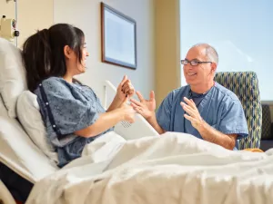 Cardiologist Eric Ewald, MD takes time to laugh and talk with patient in Lowell General Hospital's Heart and Vascular inpatient unit (D4Med).