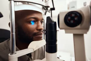 Patient getting their eye’s examined with a slit lamp during an ophthalmology appointment.