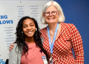 Tufts Medical Center's Associate Chief Medical Officer, Kari Roberts, MD, takes photo with a graduate during the GME residents and fellows graduation.
