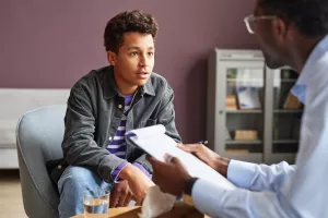 Psychologist talking to pediatric patient during a clinic appointment.