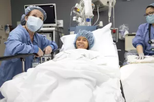 Sandra Kirby, RN, operating room nurse at Tufts Medical Center, is comforting pediatric patient in bed before surgery.