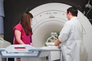 Stepahine Driver and  Evan Kyranos, both MRI Technologists, looking over and setting up MRI machine at MelroseWakefield Hospital.