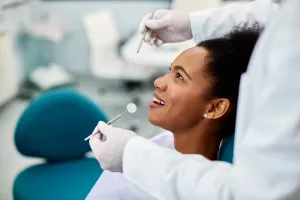 Happy patient during dental exam appointment at dentist office.