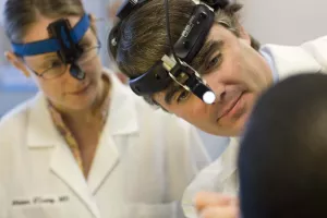 Otolaryngologist Richard Wein, MD with Miriam O'Leary, MD, using scope on patient during Ear, Nose and Throat (ENT) appointment.