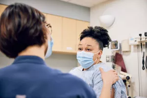 Nurse Tiano Rao comforting patient during an OBGYN Oncology appointment.