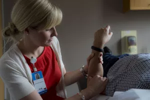 Kerry Ebert, MEd, OTR/L, adult occupational therapist, treating patient's arm.