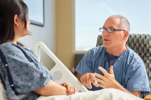 Cardiologist Eric Ewald, MD talks to patient in Lowell General Hospital's Heart and Vascular inpatient unit (D4Med).