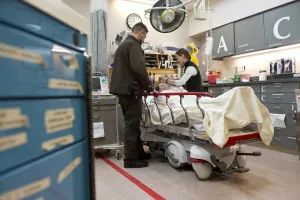 Boston EMS Jason Lapointe helps Megan Murphy, RN ready with oxygen mask patient into an emergency bay in the emergency room at Tufts Medical Center.