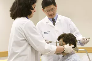 Neurosurgeon Julian Wu, MD and Kerry Mahn, RN fitting headpiece used in Gamma Knife procedure on patient at Tufts Medical Center.