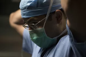 Abishnek Chatterjee, MD, MBA (Chief, Division of Plastic Surgery; Breast Surgical Oncologist; Plastic Surgeon; Breast Surgeon; Oncoplastic Specialist) putting on mask and dressing for surgery. 