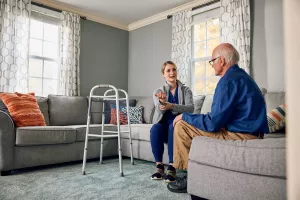 Kathleen Campbell, PT, DPT showing Care at Home patient how to use a walker and teaching best practices for wrist arm care.