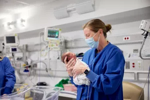 Tracy Garrett, RN holding newborn infant at MelroseWakefield Hospital's special care nursery.