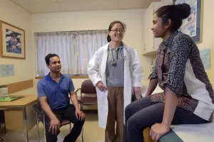  Julia (Yujuan) Zhang, MD, Pediatric Rheumatologist at Tufts Medical Center, in the clinic with patient and parent.