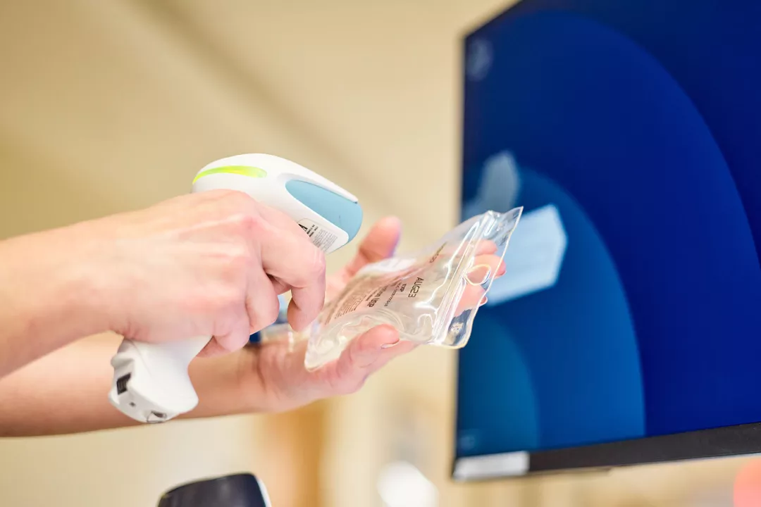 Closeup of a Lowell General Hospital nurse scanning medication at a computer workstation.