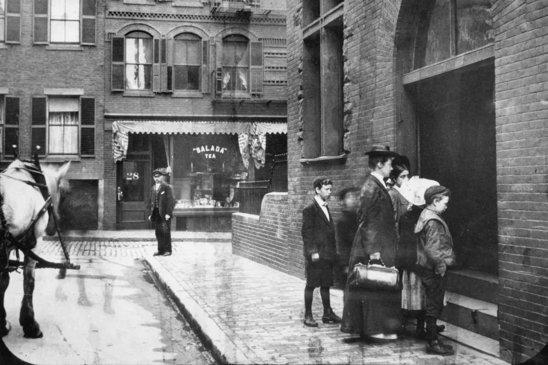 Photograph from 1910, a mother and her children approach the entrance to the dispensary to receive the care otherwise unavailable to them. 