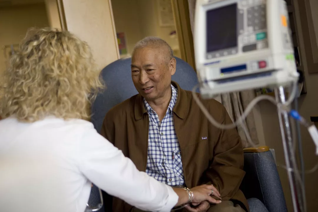 Tufts Medical Center Infusion Center patient speaks with Krista Tucker, RN, during treatment.