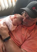 Pat with a baby in his lap Pat with a baby in his lap