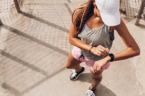 female runner checking wearable device